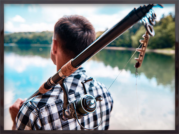 man with pole on river